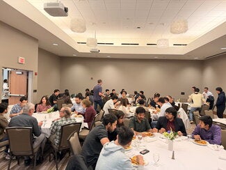 Students sitting at tables networking
