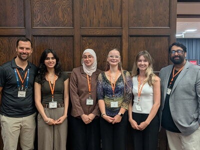 Students pose with faculty and event organizers
